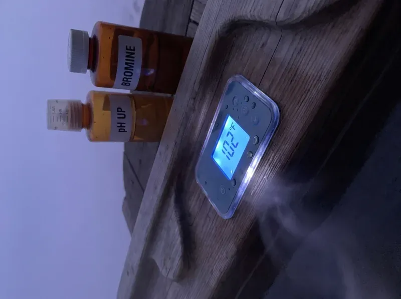 hot tub control panel at dusk showing temperature reading with bromine and pH chemicals beside it